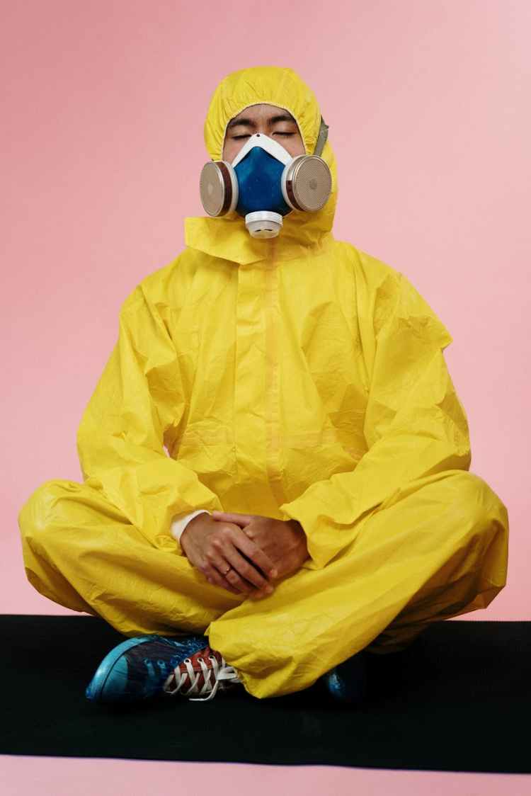 person in yellow protective suit meditating
